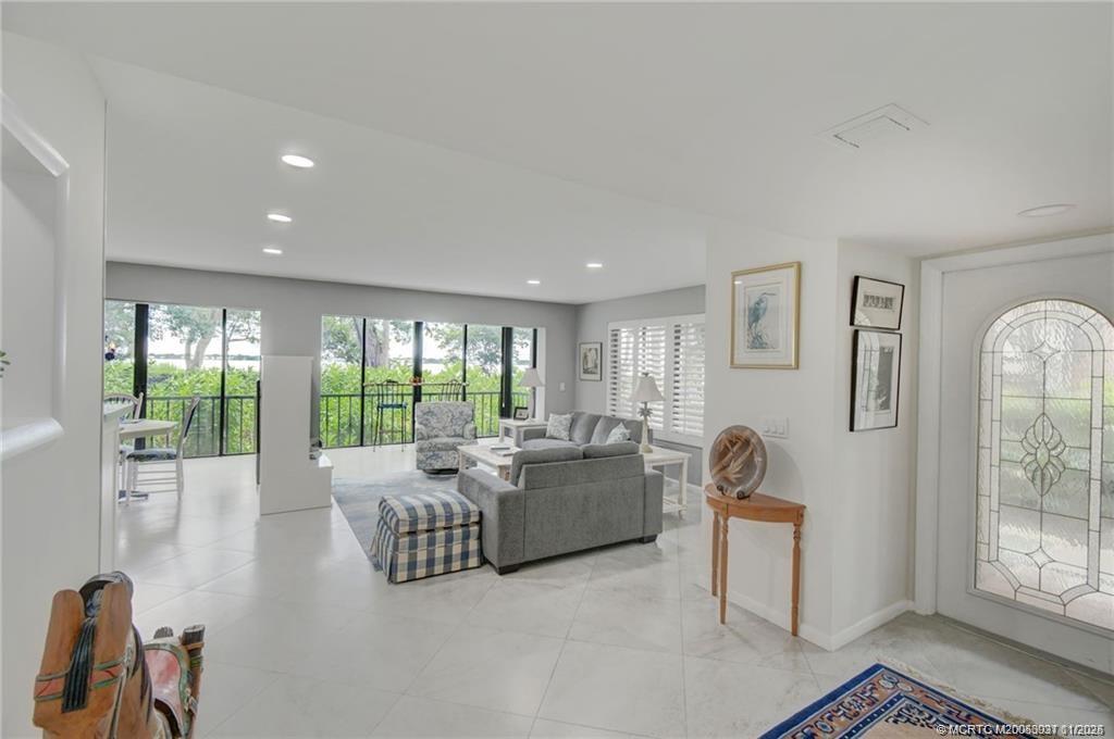 248 Northeast Edgewater Drive Stuart, FL 34996 - Photo 16 of 38 a living room with furniture and a floor to ceiling window