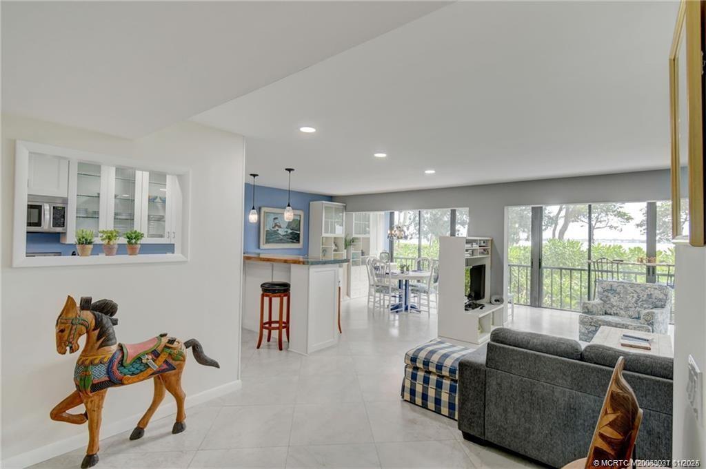 248 Northeast Edgewater Drive Stuart, FL 34996 - Photo 17 of 38 a living room with furniture and a floor to ceiling window