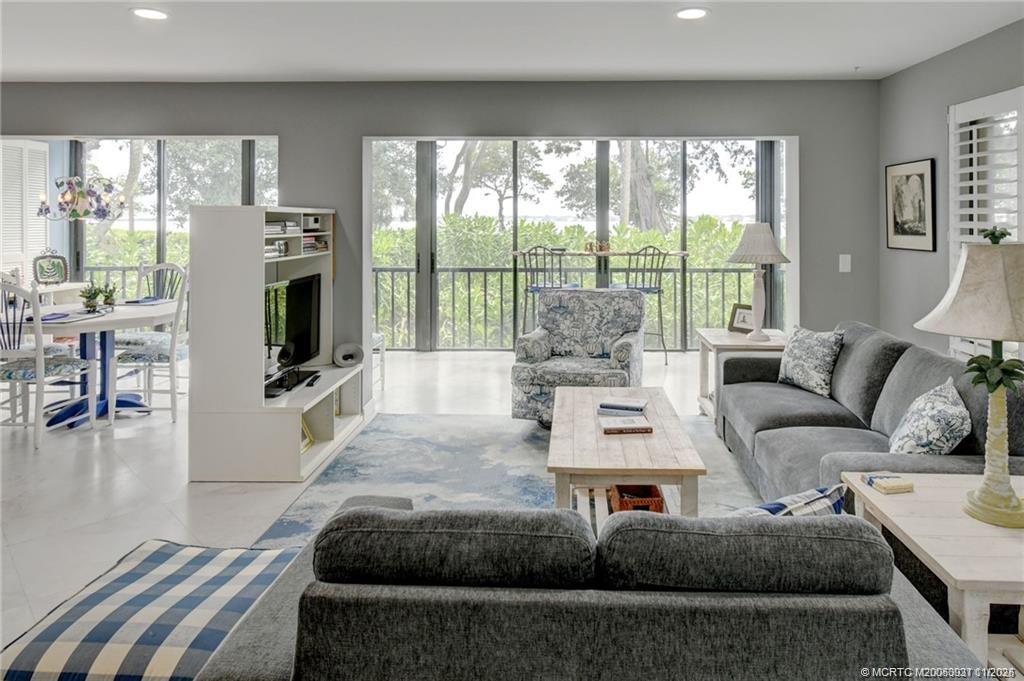 248 Northeast Edgewater Drive Stuart, FL 34996 - Photo 18 of 38 a living room with furniture large windows and a flat screen tv