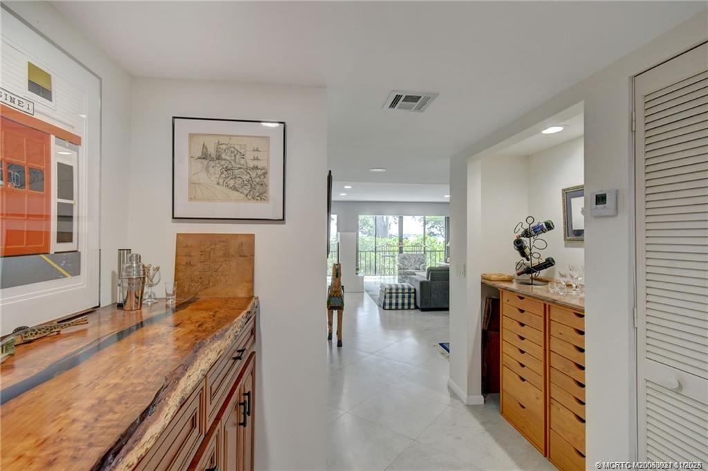 248 Northeast Edgewater Drive Stuart, FL 34996 - Photo 20 of 38 a kitchen with stainless steel appliances granite countertop a stove top oven a sink a dining table and chairs with wooden floor