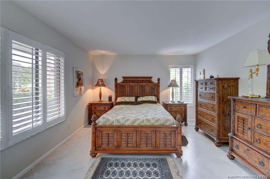 248 Northeast Edgewater Drive Stuart, FL 34996 - Photo 23 of 38 a bedroom with a bed and wooden floor