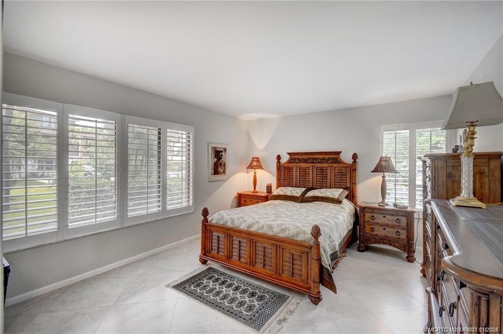 248 Northeast Edgewater Drive Stuart, FL 34996 - Photo 24 of 38 a bedroom with a bed and a window