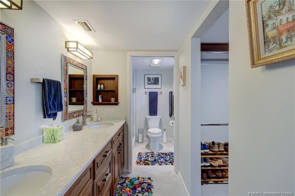 248 Northeast Edgewater Drive Stuart, FL 34996 - Photo 27 of 38 a bathroom with a sink double vanity and a shower