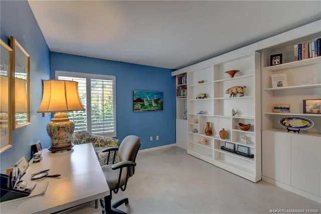 a view of a workspace with furniture and a window