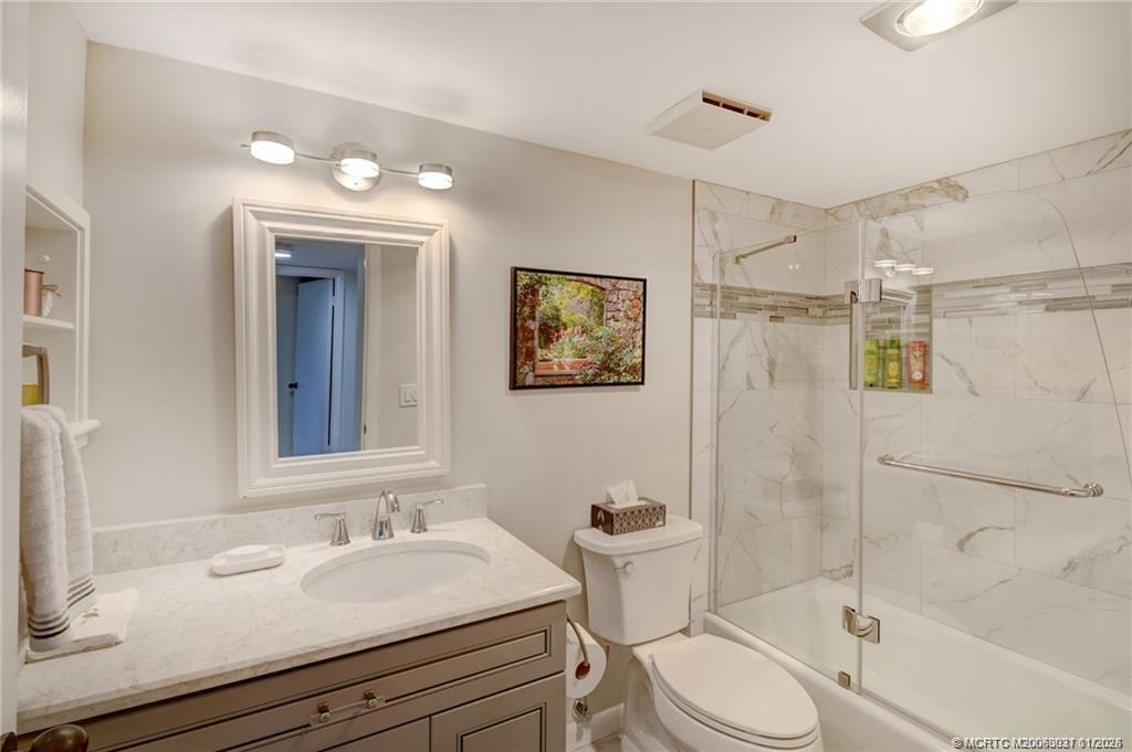 248 Northeast Edgewater Drive Stuart, FL 34996 - Photo 34 of 38 a bathroom with a sink toilet a mirror and shower