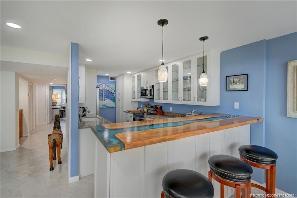 248 Northeast Edgewater Drive Stuart, FL 34996 - Photo 10 of 38 a kitchen with a sink a stove and a wooden floor