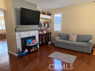17416 Birchtree Street Fontana, CA 92337 - Photo 4 of 18 a living room with furniture a flat screen tv and a fireplace