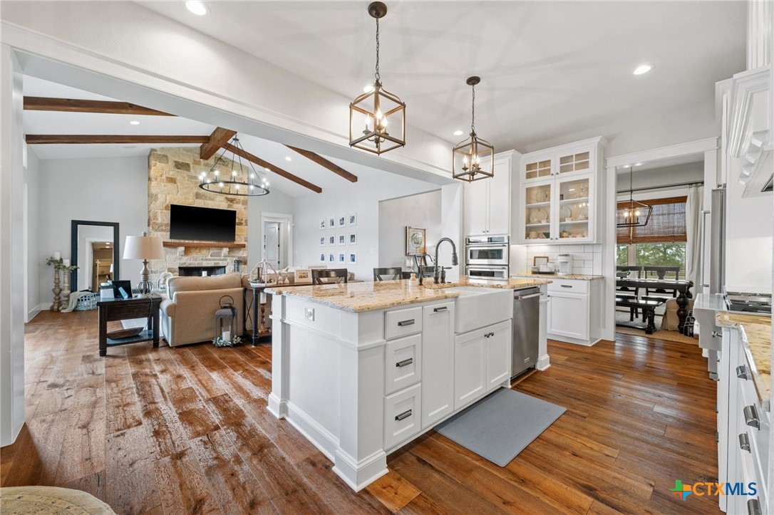 1665 Sunflower Trail Luling, TX 78648 - Photo 16 of 46 a kitchen with stainless steel appliances kitchen island granite countertop a stove a sink and a refrigerator