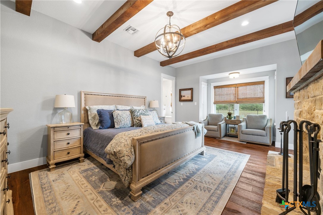 1665 Sunflower Trail Luling, TX 78648 - Photo 21 of 46 a spacious bedroom with a large bed and a chandelier
