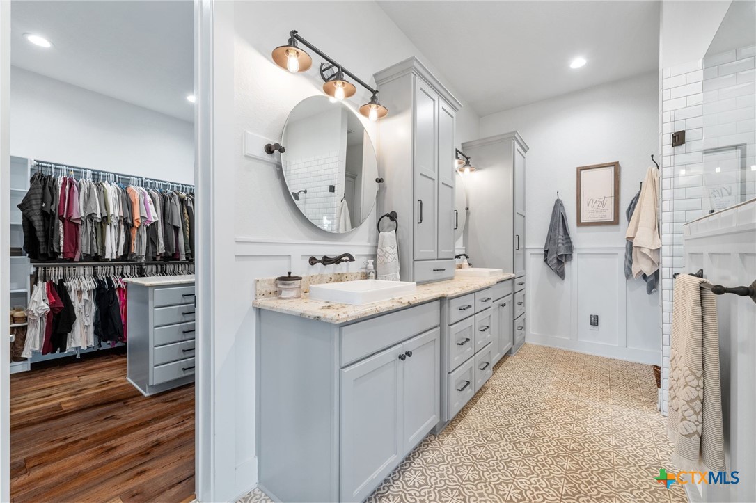 1665 Sunflower Trail Luling, TX 78648 - Photo 26 of 46 a spacious bathroom with a double vanity sink and a mirror
