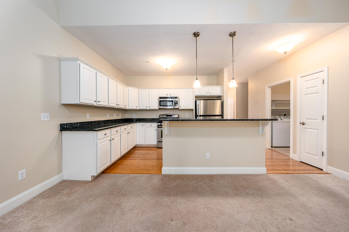 14 Chadwick Court Mashpee, MA 02649 - Photo 7 of 31 a large kitchen with stainless steel appliances kitchen island granite countertop a refrigerator a stove and white cabinets with wooden floor