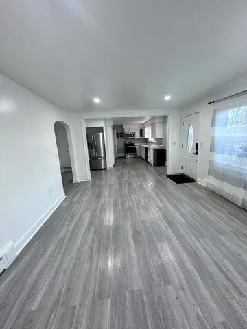 a kitchen with stainless steel appliances granite countertop a refrigerator a stove top oven a sink dishwasher and wooden floor