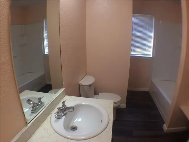 a bathroom with a sink toilet and mirror