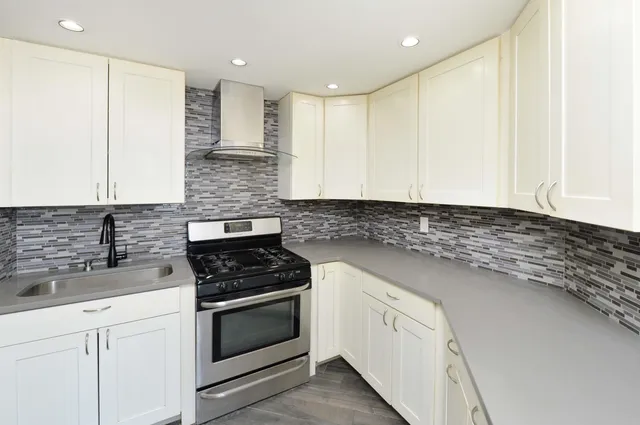 a kitchen with granite countertop white cabinets and white appliances