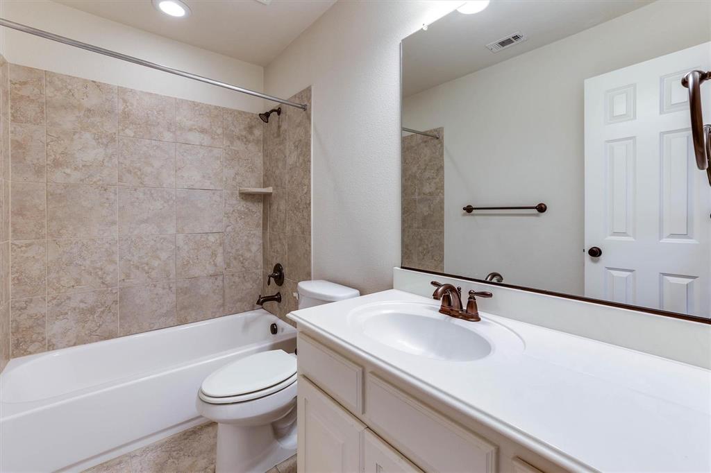 419 Rio Grande Drive Irving, TX 75039 - Photo 27 of 29 Bathroom featuring a white vanity with integrated sink, bronze-finish faucet, and full-width mirror