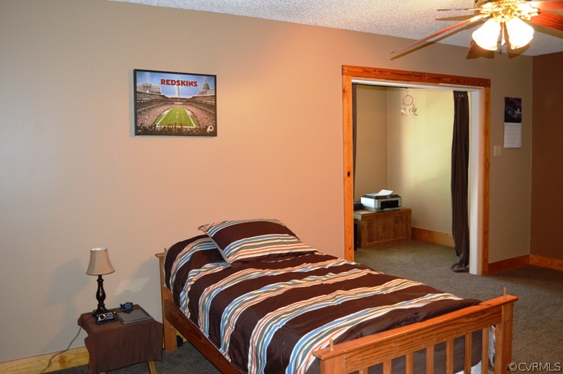 17216 Hamilton Arms Road Dewitt, VA 23840 - Photo 15 of 24 a bedroom with a bed and a chandelier