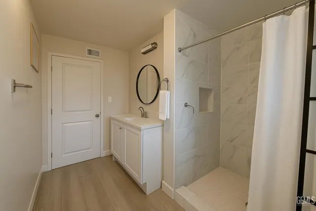 a bathroom with a shower a sink and a mirror