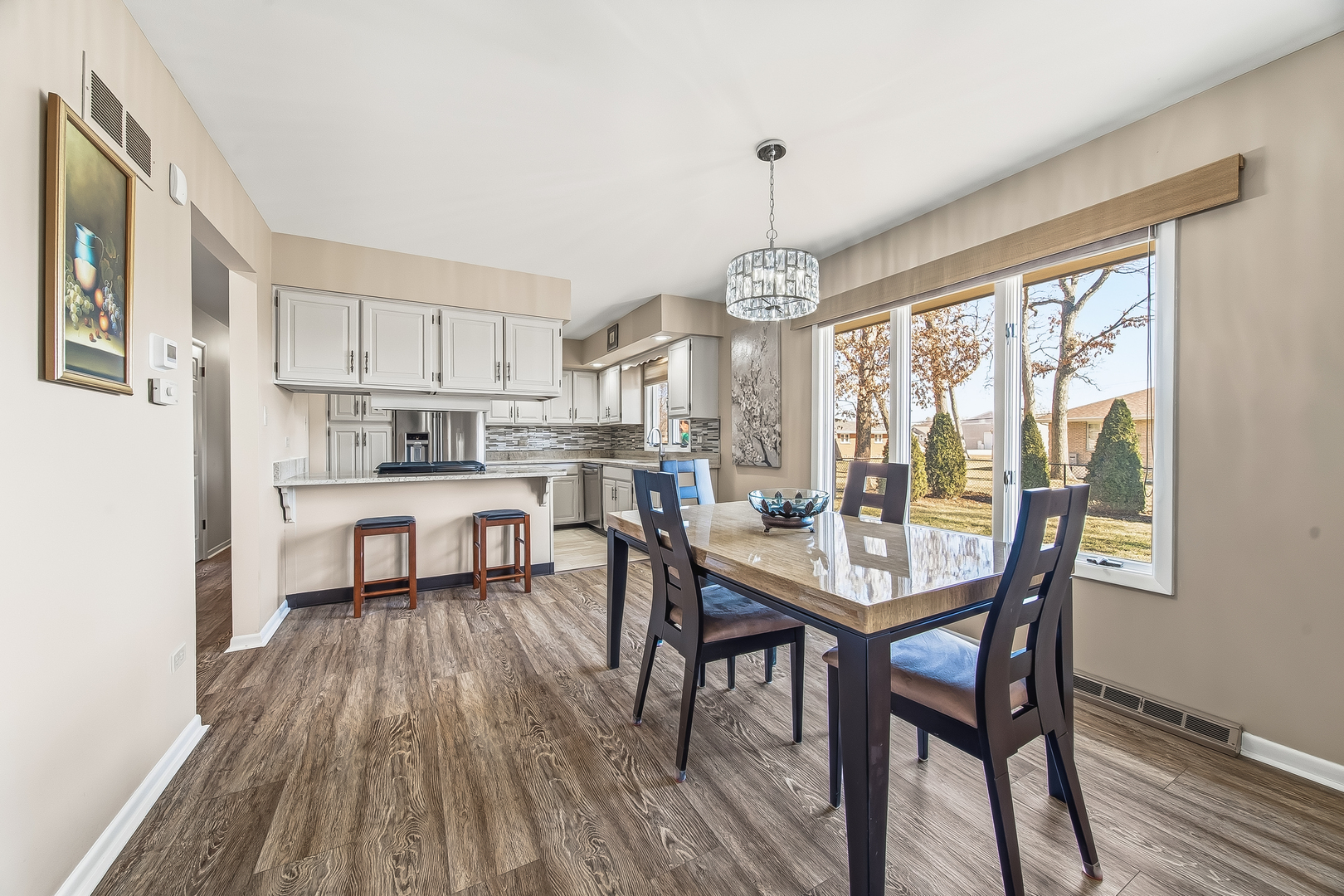 18317 Harper Street Lansing, IL 60438 - Photo 13 of 26 a dining room with stainless steel appliances a table and chairs with wooden floor