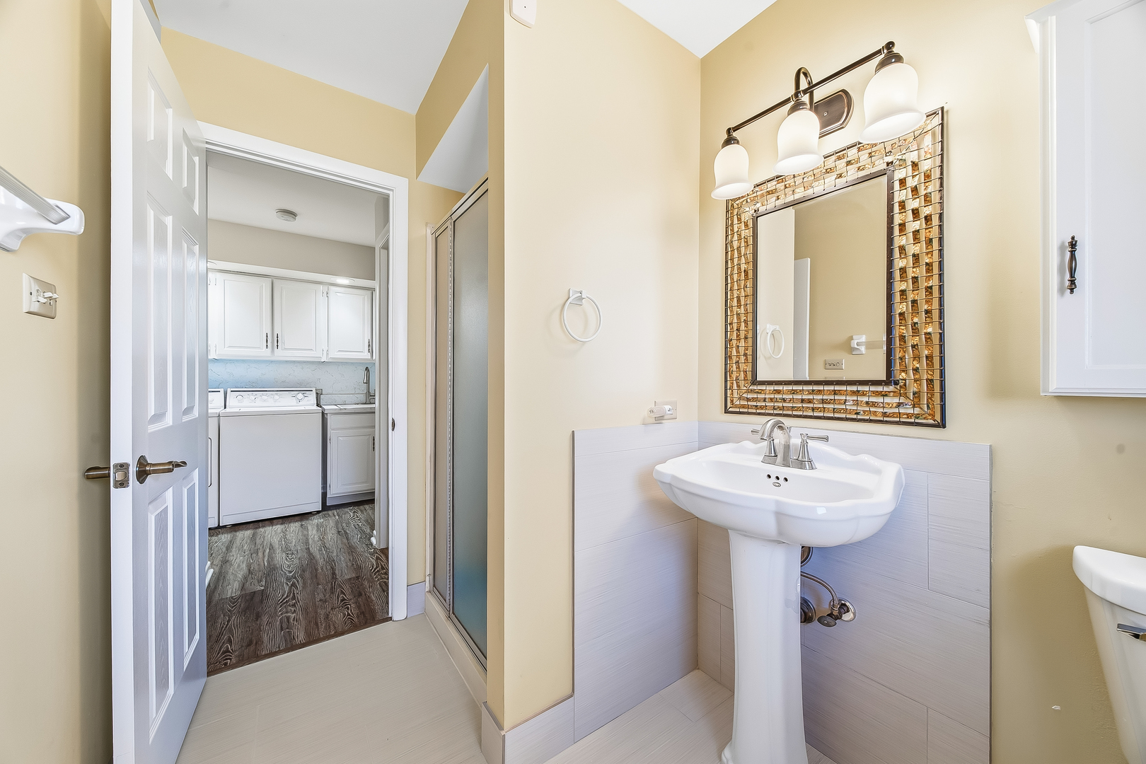 18317 Harper Street Lansing, IL 60438 - Photo 17 of 26 a bathroom with a sink a mirror a toilet and vanity