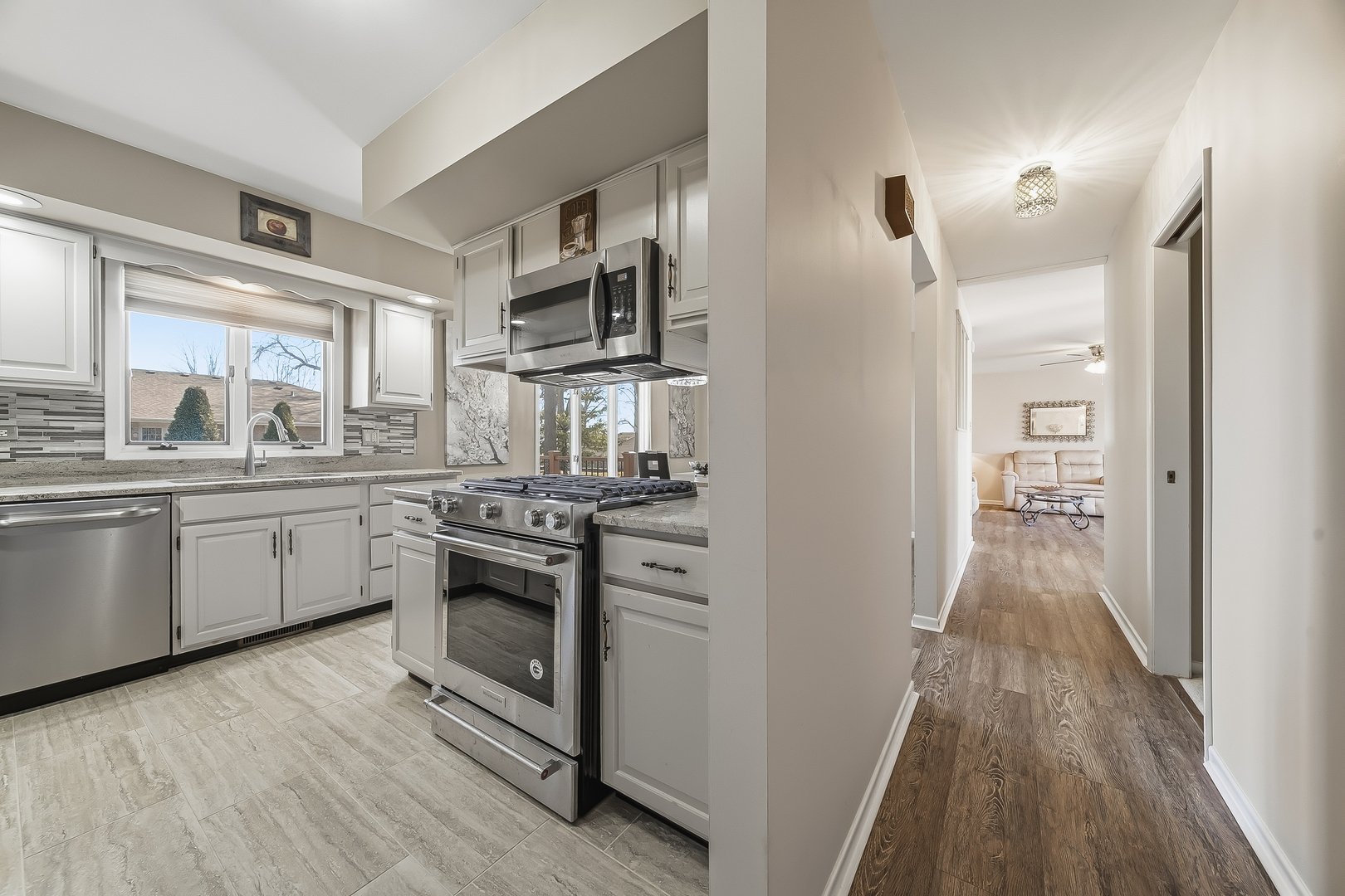 18317 Harper Street Lansing, IL 60438 - Photo 19 of 26 a kitchen with cabinets stainless steel appliances and wooden floor