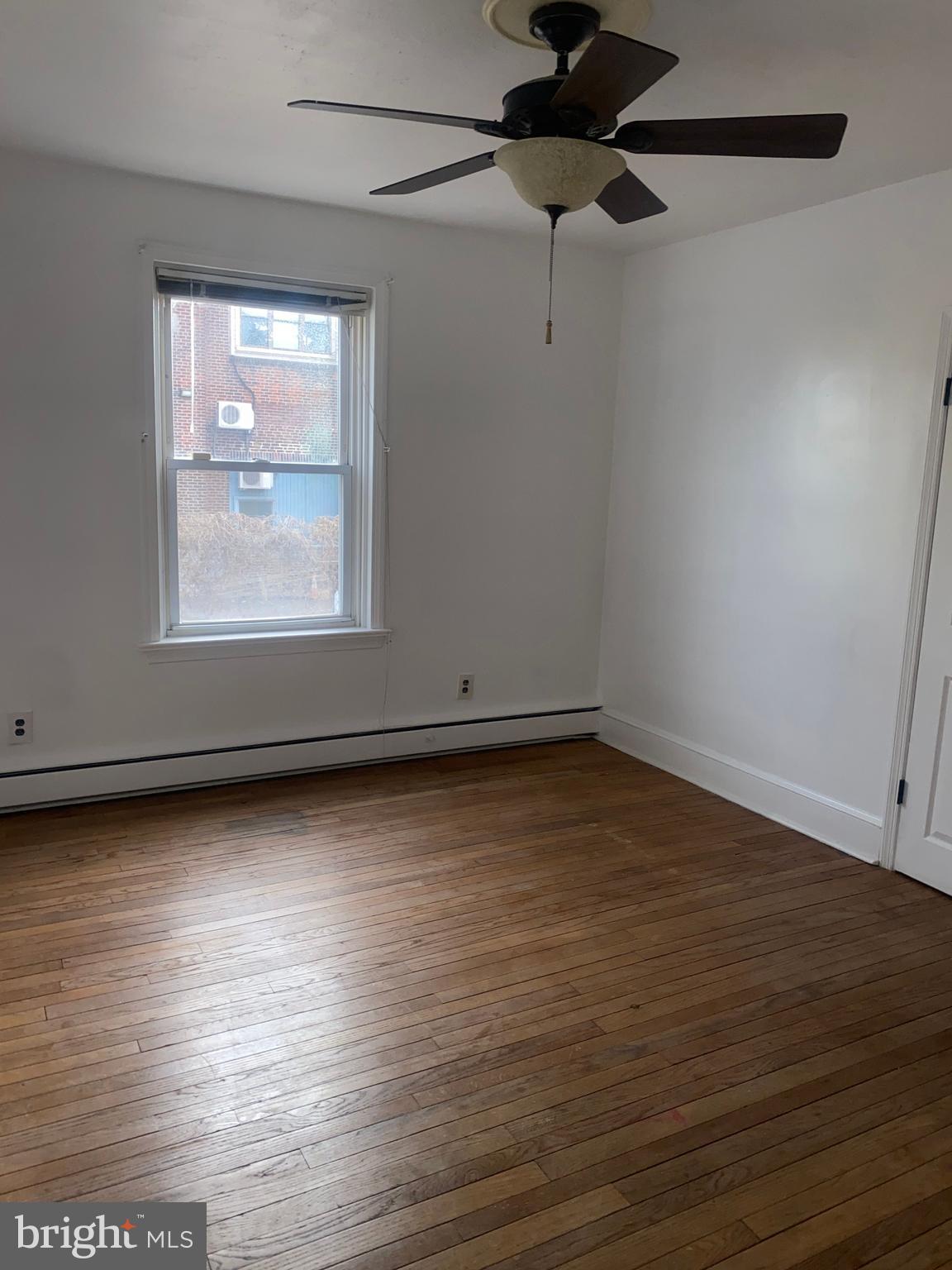 5817 Keystone Street, Unit A Philadelphia, PA 19135 - Photo 13 of 27 an empty room with wooden floor and windows