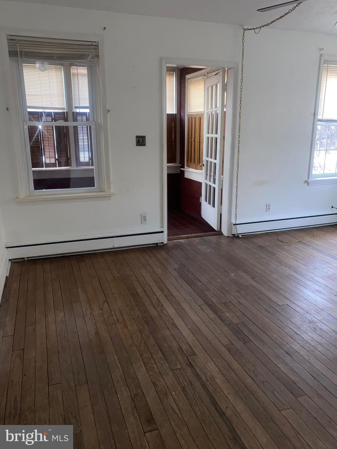 5817 Keystone Street, Unit A Philadelphia, PA 19135 - Photo 3 of 27 an empty room with wooden floor and windows