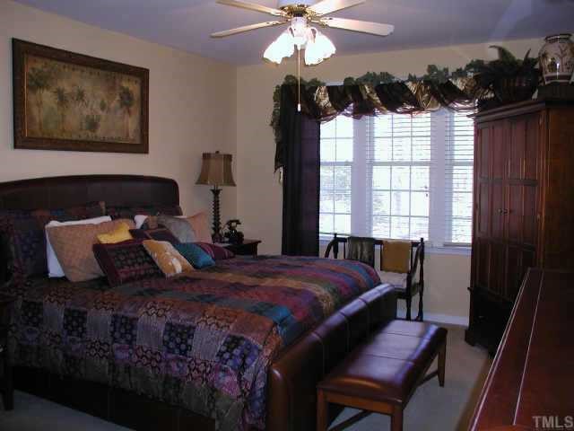 700 Neuse Ridge Drive Clayton, NC 27527 - Photo 8 of 10 a bedroom with a bed a dresser and a large mirror