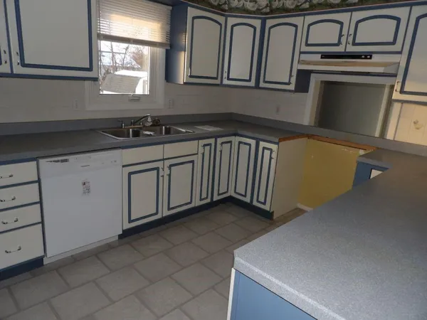 a kitchen with granite countertop a sink a stove and cabinets