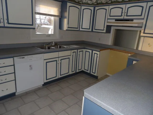 a kitchen with granite countertop a sink a stove and cabinets