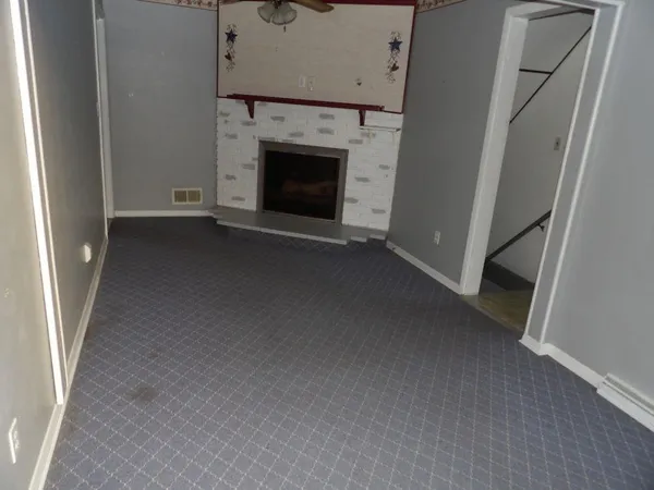 a view of empty room with a fireplace