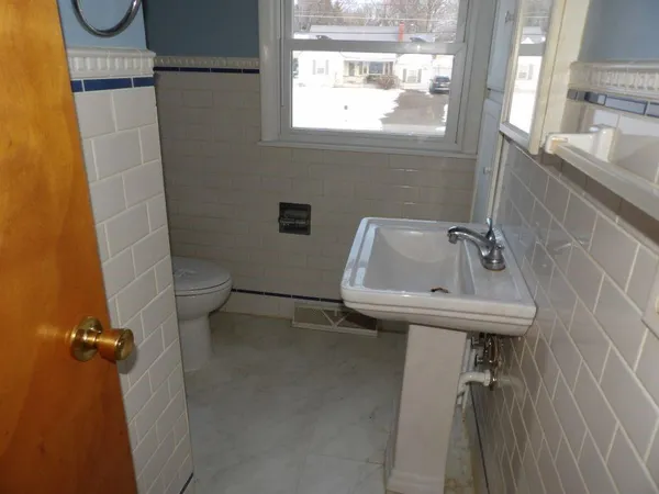 a bathroom with a sink a toilet and a window