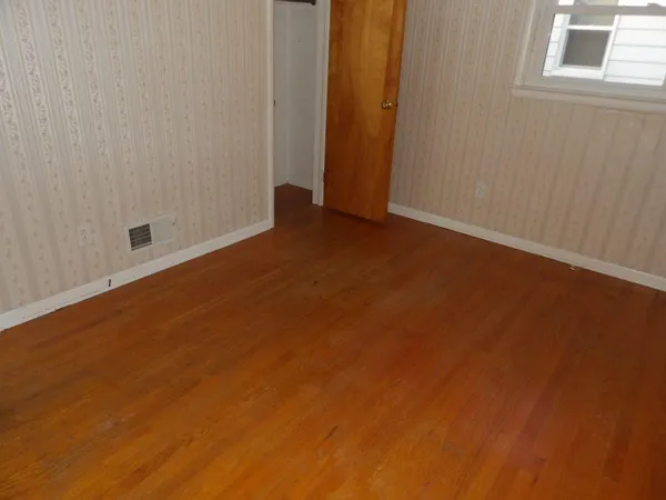 an empty room with wooden floor