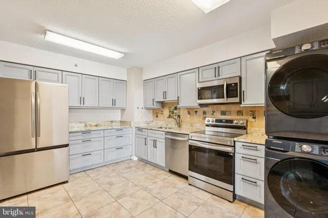 a kitchen with cabinets stainless steel appliances and a sink