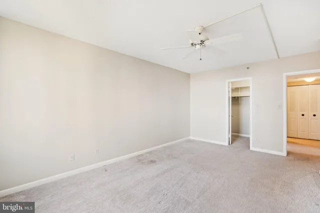 an empty room with a ceiling fan and a window