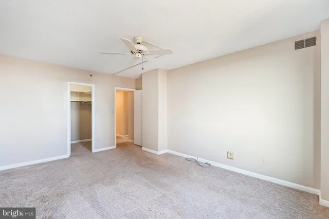 an empty room with a ceiling fan and a window