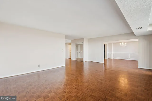 a view of empty room with wooden floor