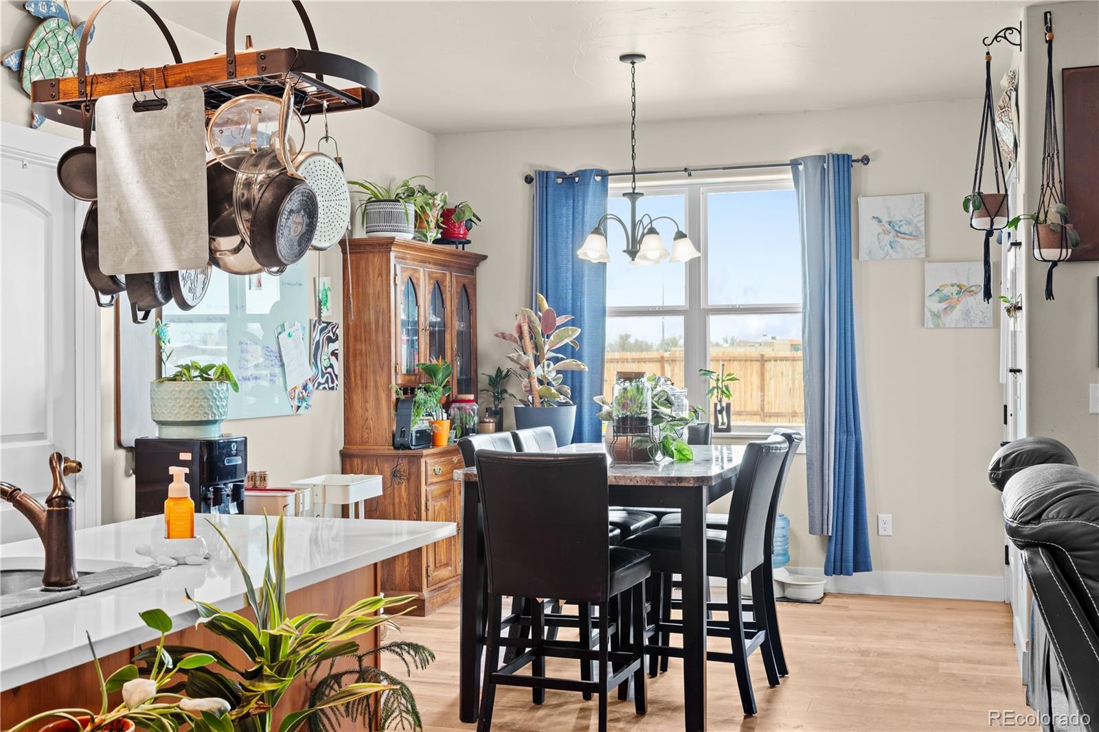 109 7th Avenue Wiggins, CO 80654 - Photo 12 of 38 a view of a dining room and livingroom with furniture wooden floor a chandelier