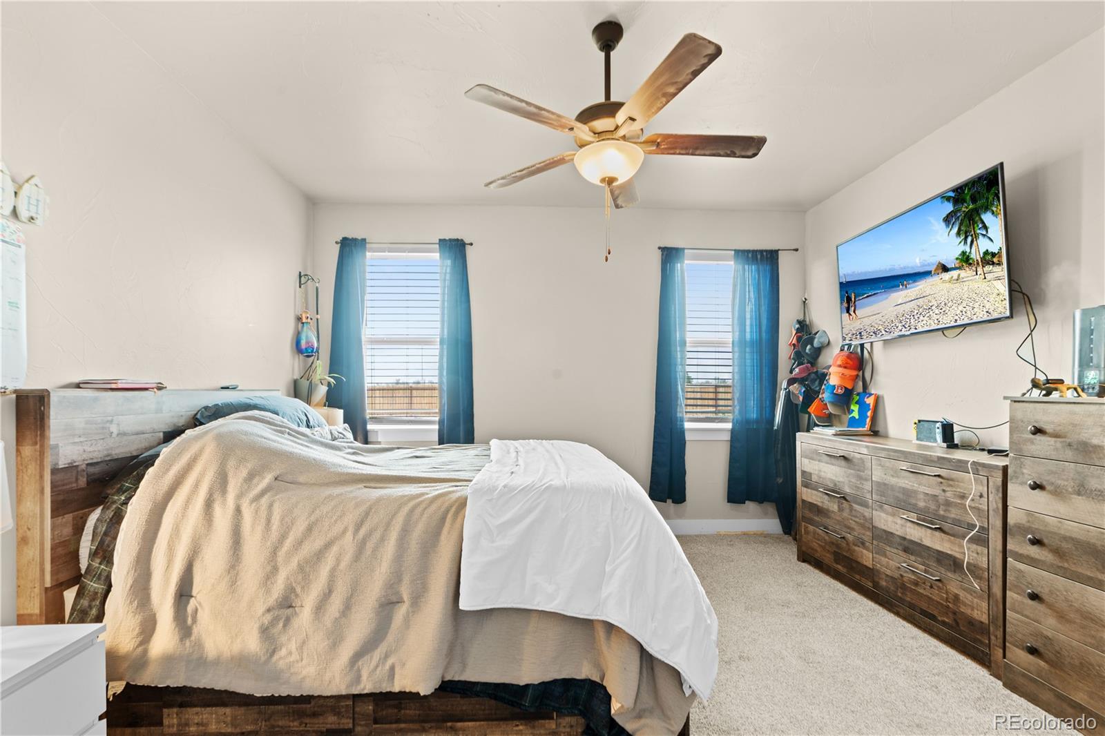109 7th Avenue Wiggins, CO 80654 - Photo 19 of 38 a bedroom with a bed and ceiling fan