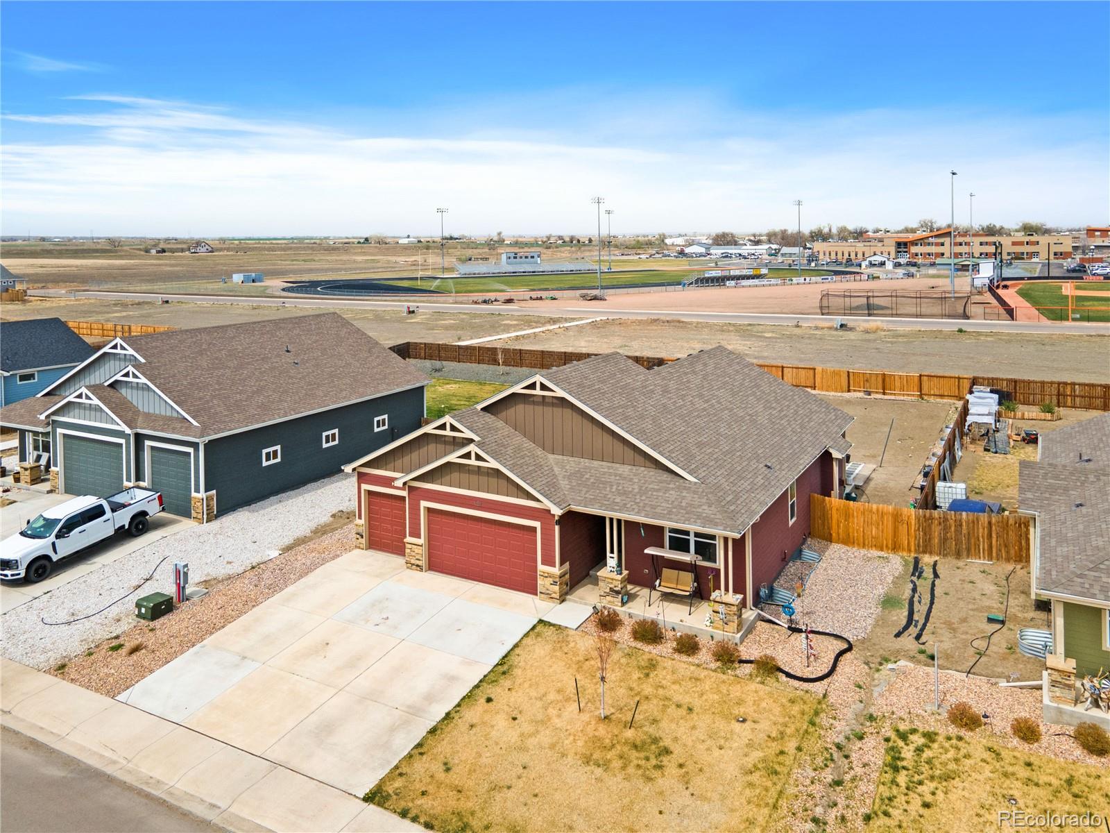 109 7th Avenue Wiggins, CO 80654 - Photo 2 of 38 an aerial view of a house with a big yard and palm tree