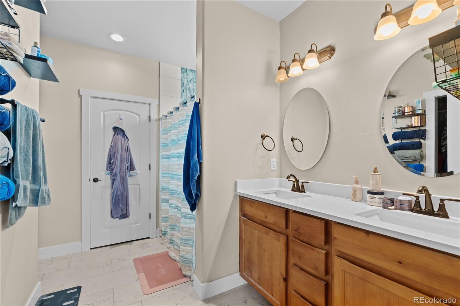 109 7th Avenue Wiggins, CO 80654 - Photo 21 of 38 a bathroom with a double vanity sink mirror and shower