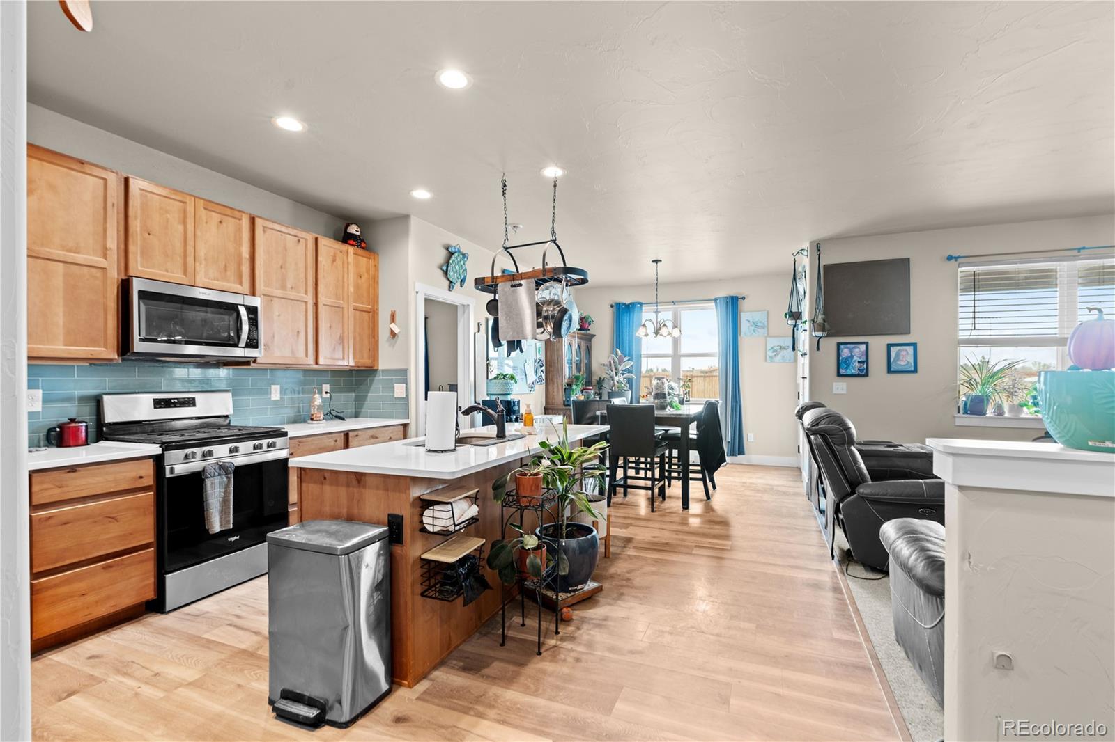 109 7th Avenue Wiggins, CO 80654 - Photo 3 of 38 a view of kitchen with microwave stove refrigerator dining table and chairs