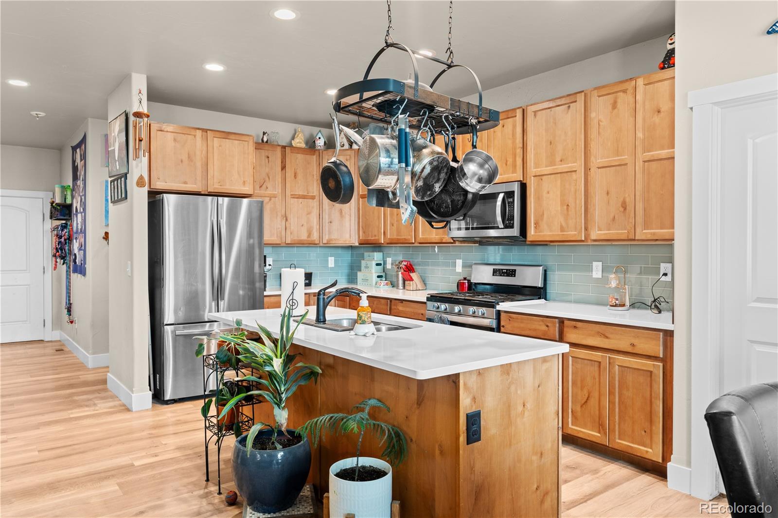 109 7th Avenue Wiggins, CO 80654 - Photo 8 of 38 a kitchen with stainless steel appliances granite countertop a sink a stove and a refrigerator