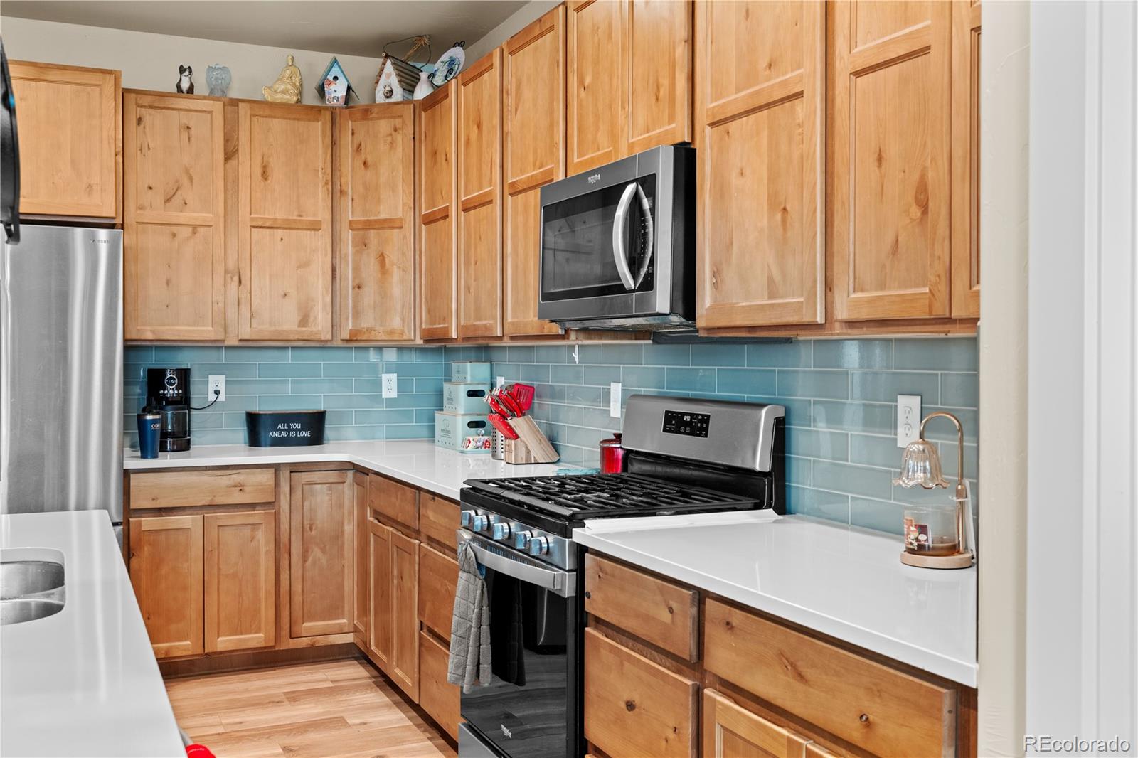 109 7th Avenue Wiggins, CO 80654 - Photo 9 of 38 a kitchen with stainless steel appliances granite countertop a stove a sink and a microwave