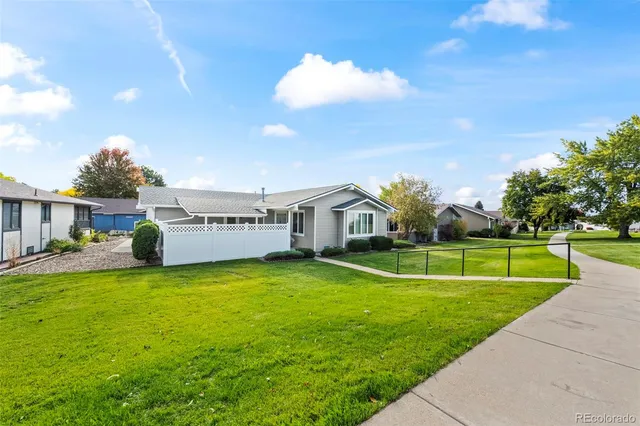 a view of a house with a big yard and a large tree