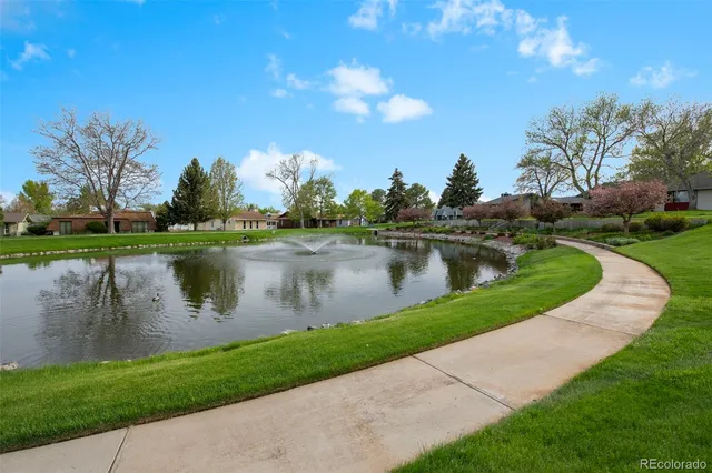 a view of a lake with a yard and large trees