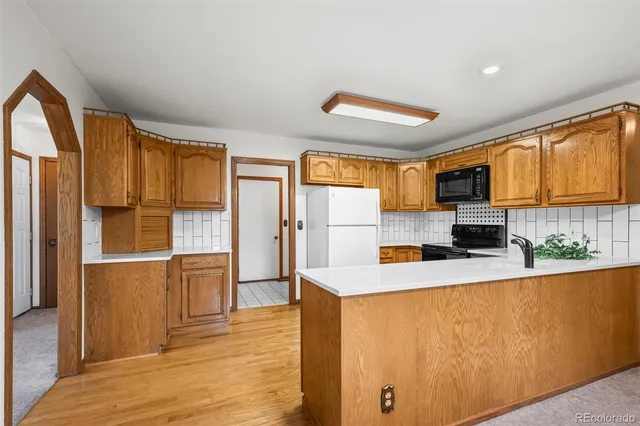 a kitchen with stainless steel appliances granite countertop a refrigerator a stove top oven a sink and dishwasher