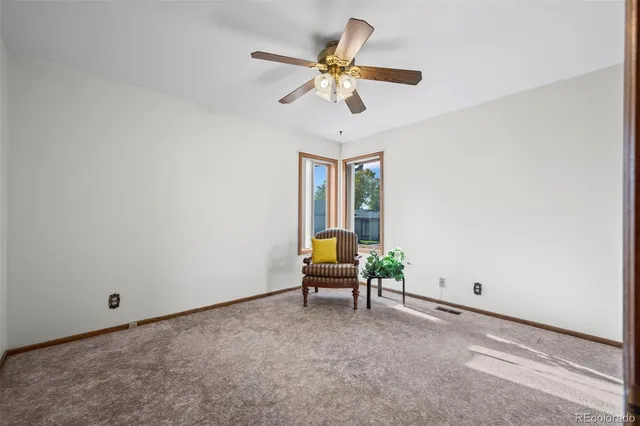 a living room with furniture and a ceiling fan