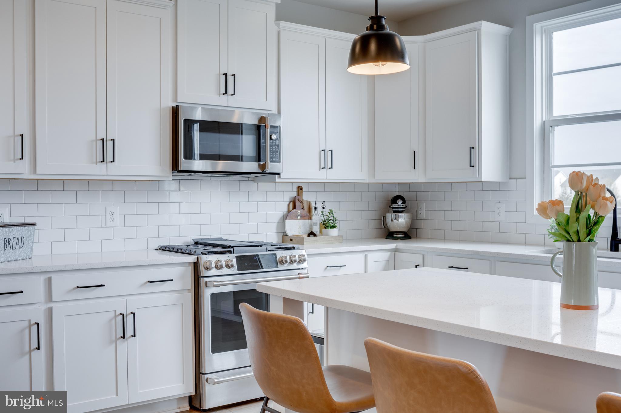 14488 Nebbiolo Drive Gainesville, VA 20155 - Photo 24 of 54 a kitchen with stainless steel appliances a stove a white cabinets and a wooden floor