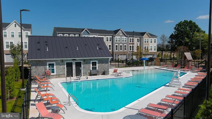 14488 Nebbiolo Drive Gainesville, VA 20155 - Photo 44 of 54 a view of a house with pool lawn chairs and a yard
