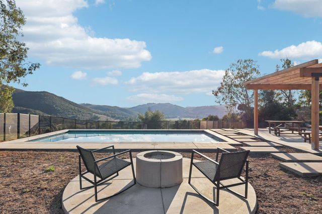 a kitchen with stainless steel appliances granite countertop a refrigerator a sink dishwasher a stove top oven a refrigerator with wooden cabinets and floor